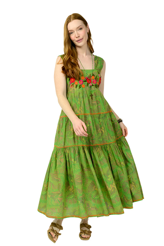 Woman wearing a green dress with floral embroidery on a white background
