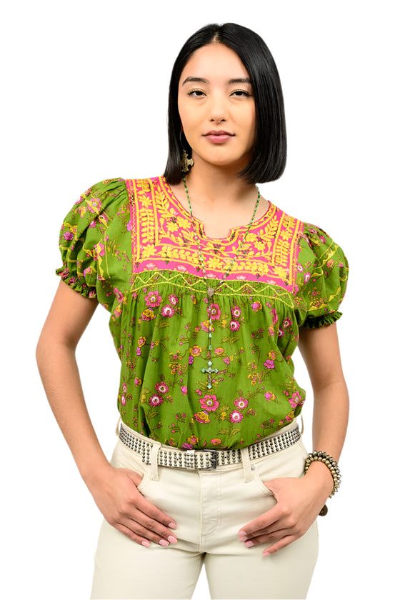 Woman wearing a green floral blouse with pink accents on a white background