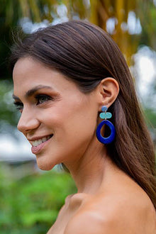  Woman wearing colorful earrings with a blurred natural background