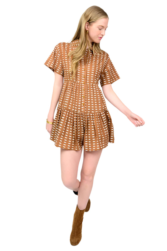 Woman wearing a brown patterned romper with short sleeves on a white background