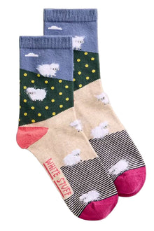  Three pairs of socks with sheep designs on a light gray background