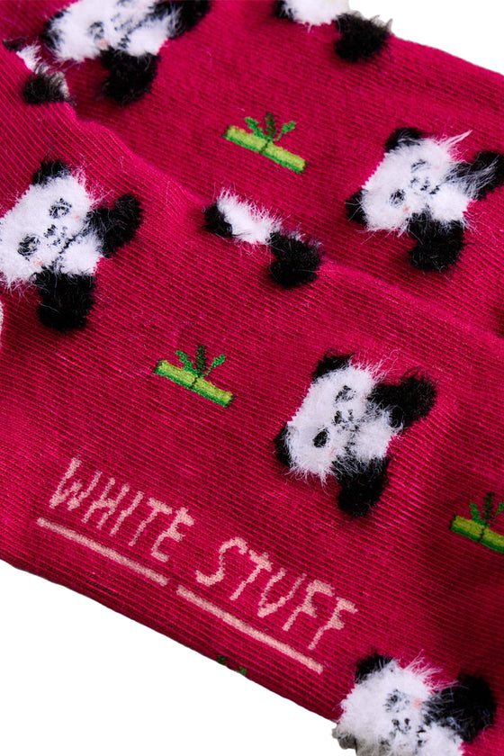 Red sock with panda pattern and 'White Stuff' branding on a beige surface