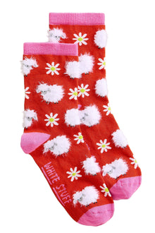  Red socks with white fluffy sheep and yellow flowers on a light gray background