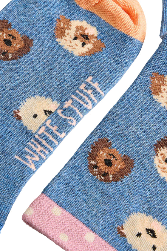 Blue socks with hedgehog pattern and 'White Stuff' branding on a light background